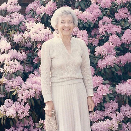 dolly ahrens in front of her purple flowers